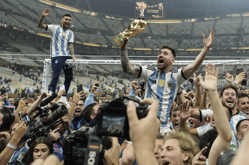 Lionel Messi and the Argentina national team celebrate their 2022 FIFA World Cup victory in front of their fans.