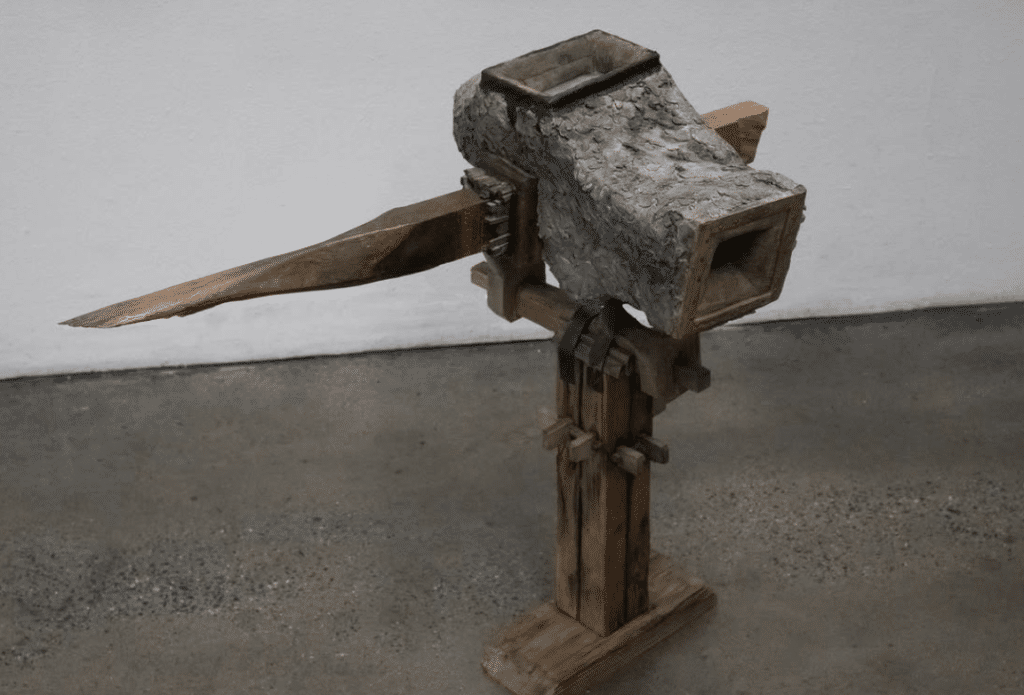 Elijah Smith's sculpture, which is an abstract anvil-like object with various wooden components.