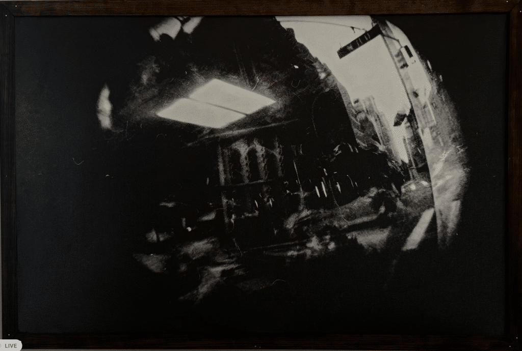 Warped photograph of a black and white road with a light superimposed.