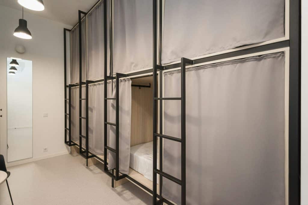 Capsule bunks with privacy screens in a hostel room