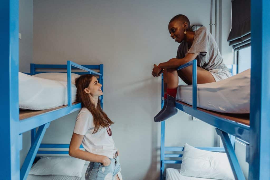 Two female travellers chatting on bunk beds