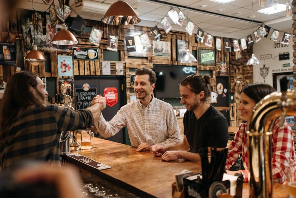 A group of young travellers chatting at a bar